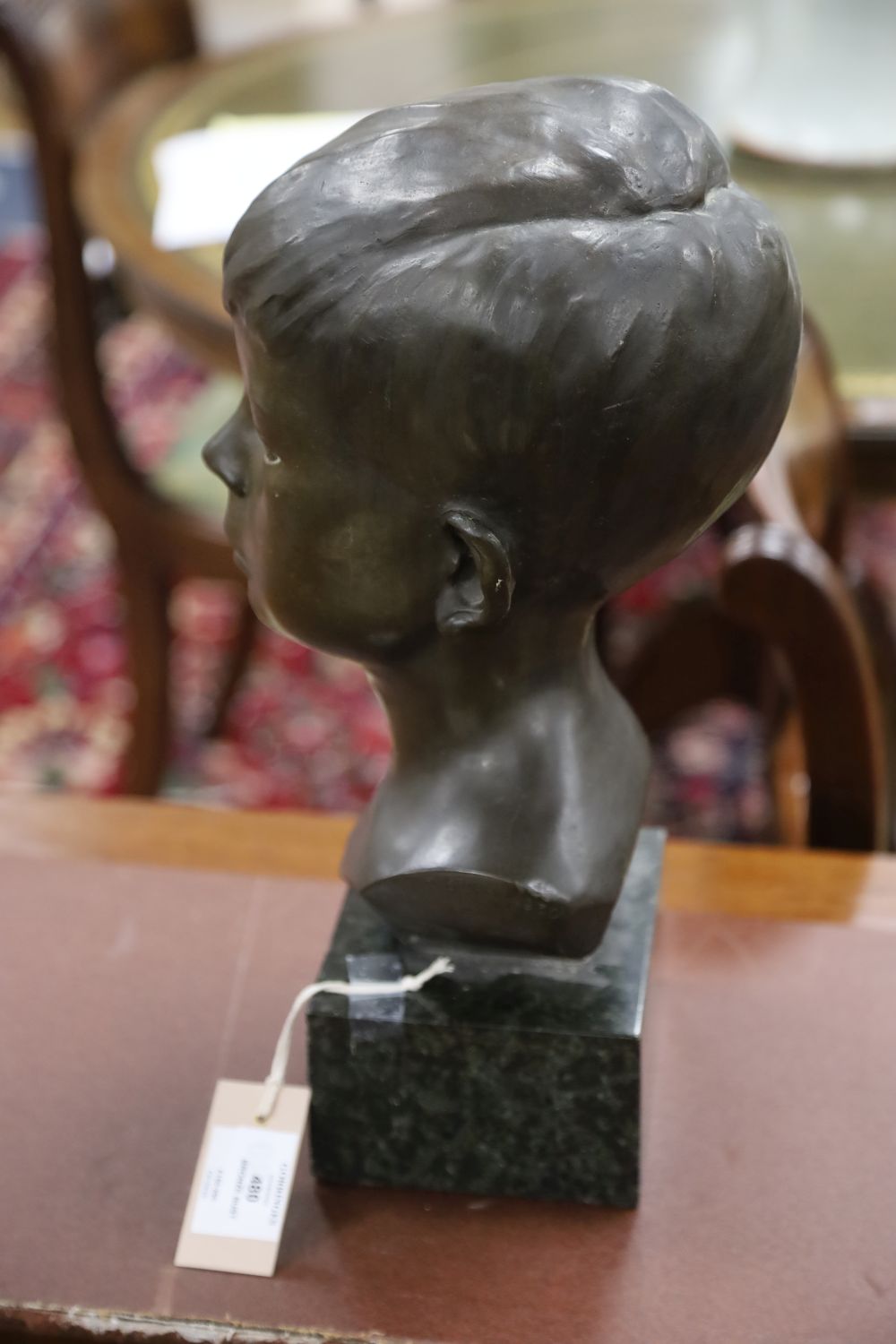 A bronze bust of a boy, signed R.Swann 1930, on marble base, height 38cm, some scuffing to the nose shows some white metal although we